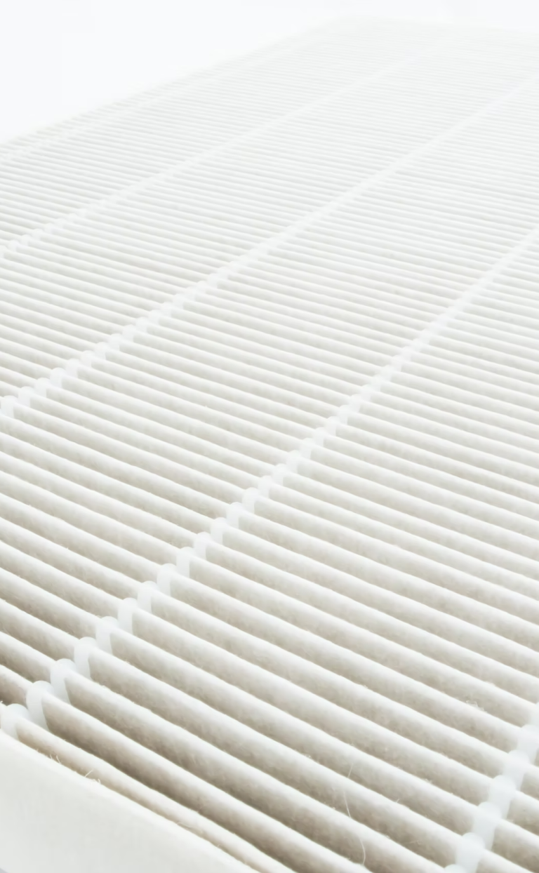 Nahaufnahme eines weißen Luftfilters mit parallelen Rillen.